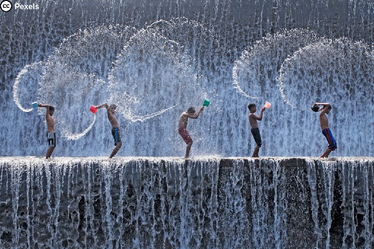 Fünf Jungs spielen auf einem Wasserfall. Foto von Jeffry S.S. auf Pexels.