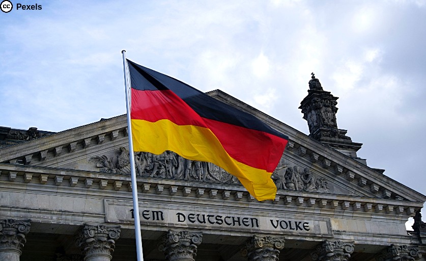 Vor dem Bundestag weht die Deutschlandfahne in schwarz-rot-gold. Foto von Ingo Joseph von Pexels.